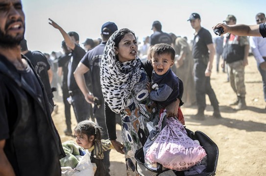 A Syrian Kurdish woman crosses the border between Syria and Turkey at the southeastern town of Suruc in Sanliurfa province on September 23, 2014. The UN refugee agency warned Tuesday that as many as 400,000 people may flee to Turkey from Syria's Kurdish region to escape attacks by the Islamic State group.  (BULENT KILIC/AFP/Getty Images)