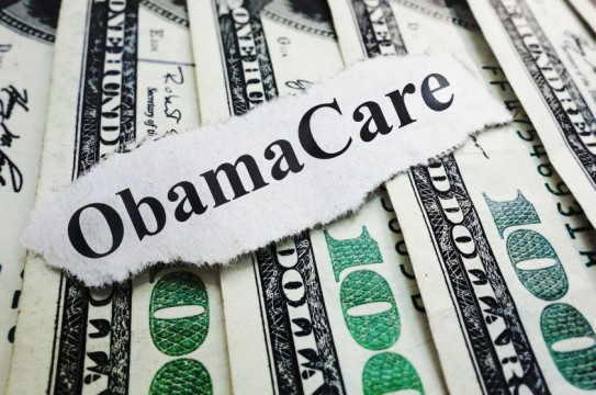 Closeup of an Obamacare newspaper headline on cash