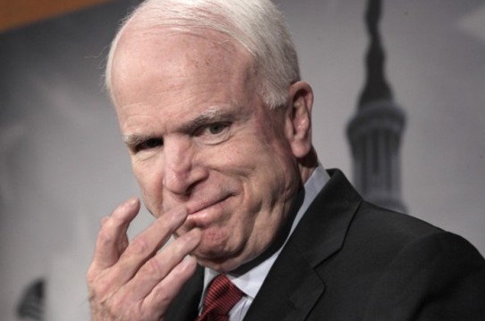 In this photo taken Dec. 14, 2011, Sen. John McCain, R-Ariz., smiles during a news conference on Capitol Hill in Washington. McCain has drawn the ire of Russian Prime Minister Vladimir Putin after the senator goaded Putin in a Twitter post about mass protests in Russia over alleged vote fraud. Putin lashed back at  McCain saying, "He has a lot of blood of peaceful civilians on his hands," referring to McCain's role as a combat pilot and prisoner of war in Vietnam. (AP Photo/J. Scott Applewhite)